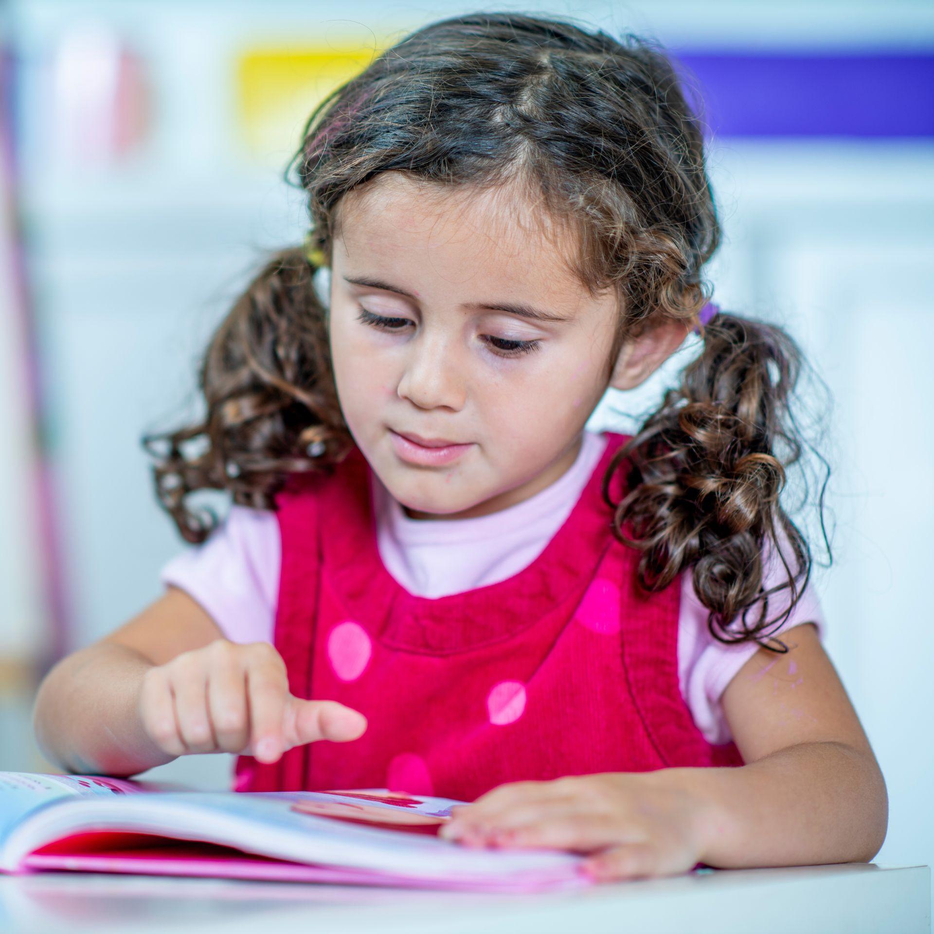 Little girl focused on reading a book