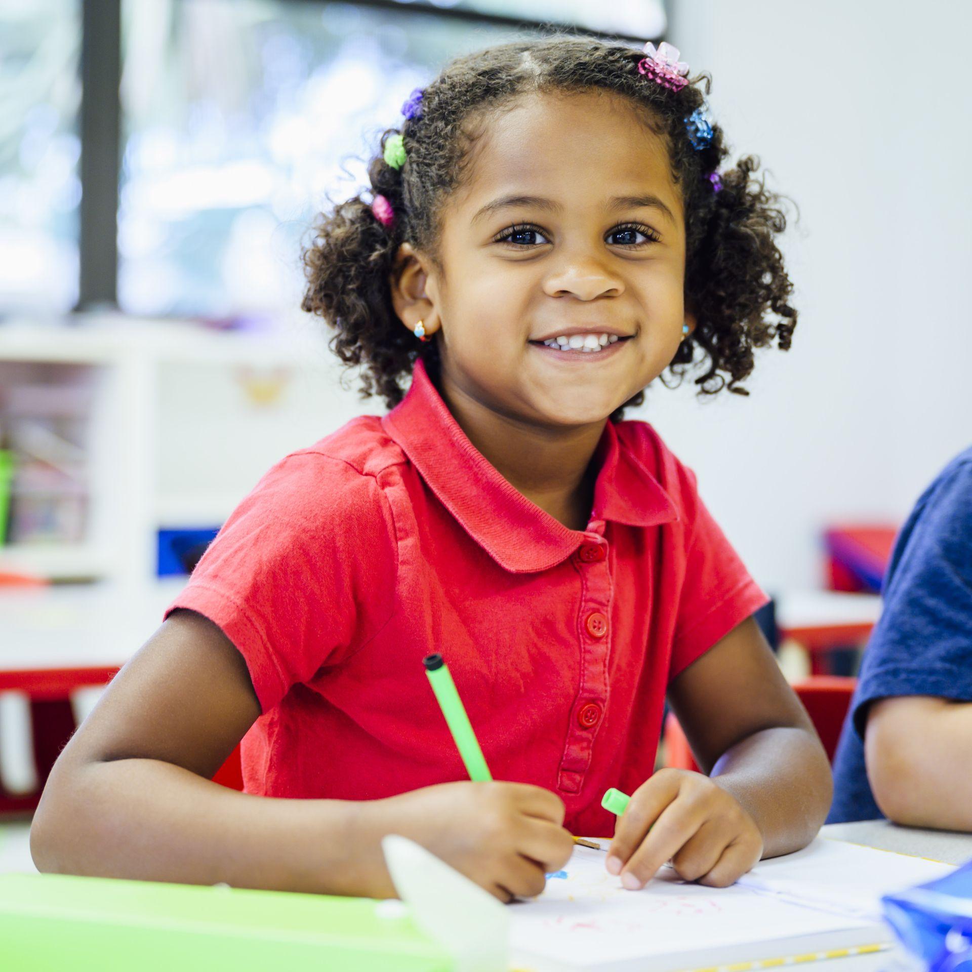 Little girl smiling while writing